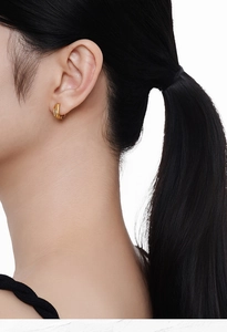 Three-row gold hoop earrings with pavé stones shown on an elegant female model
