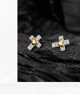 Détail de boucles d'oreilles croix en argent S925 avec cœur doré et pavé scintillant