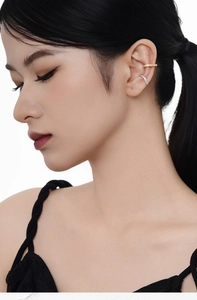 Detail of S925 silver geometric ear cuffs with sparkling diamonds on a female model