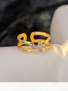 Détail d'une bague double croix dorée avec pavage scintillant de cristaux de zircone