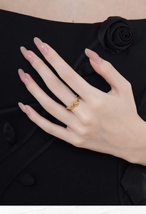 Detail of S925 silver snake-shaped entwined ring on finger with two-tone gold and silver finish