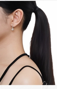Close-up of S925 sterling silver shell earring with pearl on female model ear