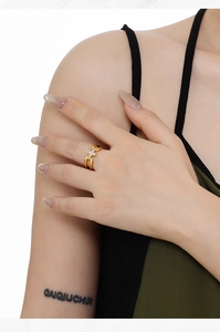 Détail de la bague croisée dorée avec anneaux ajourés et oxydes de zirconium brillants