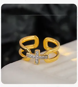 Vue macro d'une bague croix dorée avec zircons sertis sur une pierre blanche