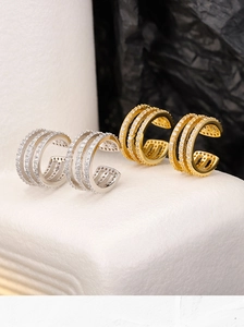 Macro detail of triple-layered geometric ear cuffs with micro-set sparkling white stones