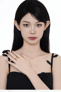 Detail view of a gold-toned snake wrap ring on a model hand with minimalist style