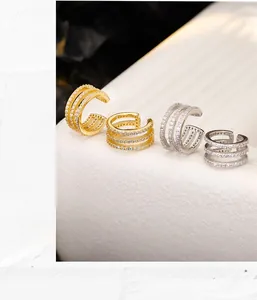 Close-up of triple-layered gold and silver ear cuffs with micro-pave zircon settings