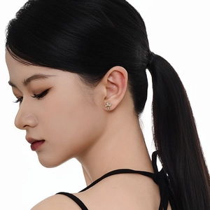 Clou d'oreille croix en argent S925 avec cœur doré porté par un mannequin féminin