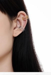 Detail of triple-layer gold and silver ear cuffs with sparkling crystals on ear