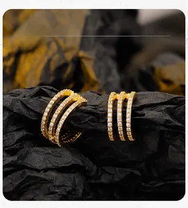 Macro detail display of golden three-layer geometric ear cuff with pave set cubic zirconia
