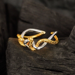 Two-tone S925 sterling silver snake ring with pavé crystals on textured dark wood background