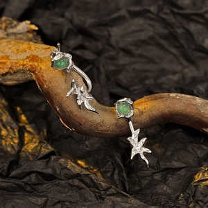 Artistic display of S925 silver flower petal earrings with green aventurine on dark branch