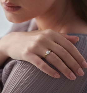 Detail of square zircon cluster ring in gold finish worn by model with silk background