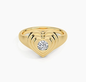 Macro shot of tiered heart-shaped gold ring featuring a brilliant round center stone