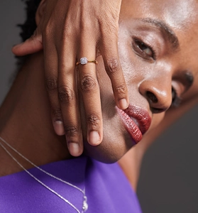 Close-up of elegant gold square diamond cluster ring worn by a female model