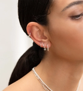 Dettaglio di orecchini a cerchio in argento sterling S925 con ciondoli in zircone su modella