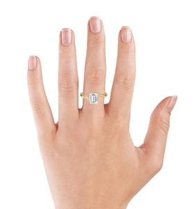 Close-up of a square emerald cut zircon ring in gold finish on a model's hand
