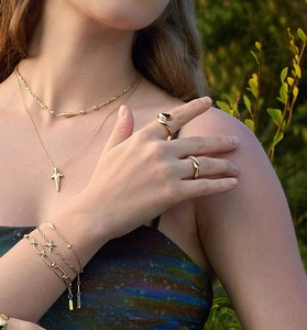 Detailansicht eines Models mit mehrlagigem Goldschmuck mit Stern- und Rautenanhängern