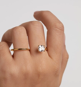 Detail of S-shaped gold S925 silver ring featuring a cushion-cut square cubic zirconia