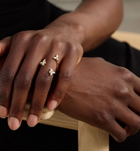 Detail shot of a gold butterfly ring with marquise zircon stones on a model's hand