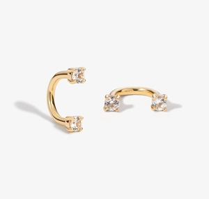 Detail of S925 sterling silver U-shaped gold earrings with prong-set cubic zirconia