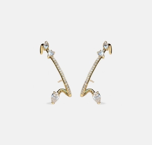 Macro detail of S925 silver ear cuffs featuring gold plating and pear-cut cubic zirconia