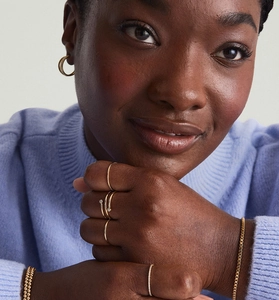 Close-up of golden multi-layer rings, earrings and bracelets on a female model
