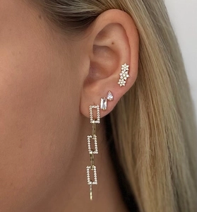 Gros plan d'un ensemble de boucles d'oreilles en argent S925 et zircon sur l'oreille