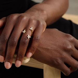 Elegant gold open ring with three sparkling butterfly charms on a finger