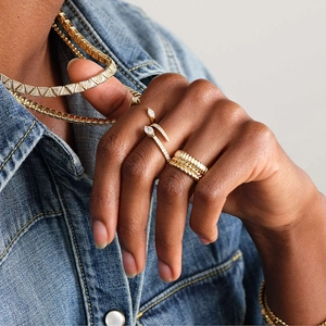 Elegantly layered S925 sterling silver rings and chain necklace on denim background