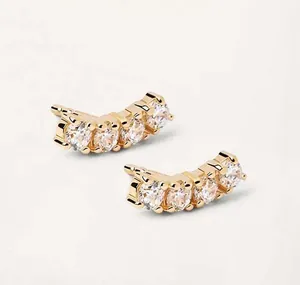 Detailed macro view of S925 silver curved gold earrings with five clear cubic zirconia gems