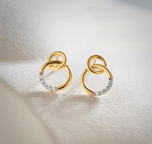 Macro shot of interlocking golden double rings with pave-set sparkling white zircons