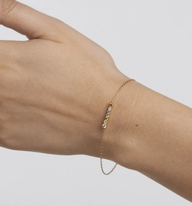 Macro detail of gold S925 sterling silver bracelet with five colored zircon stones on wrist