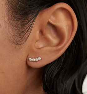 Detailed view of S925 silver curved ear stud with four sparkling white zircons on ear
