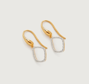 Close-up of gold-plated geometric hollow earrings with sparkling white pavé stones