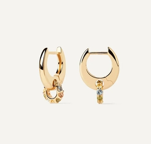 Macro shot of gold hoop earrings with multi-colored gemstone charms on ivory background