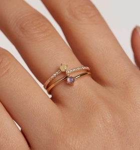 Close-up of stacked S925 sterling silver rings with purple and yellow zircon stones
