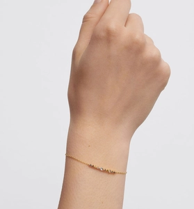Macro shot of colorful cubic zirconia stones on gold chain bracelet on wrist