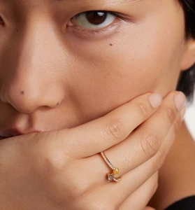 Close-up of gold S925 silver ring with yellow and white zircon stones on model's hand