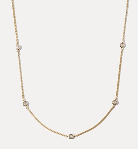 Détail macro du collier plaqué or avec cinq pendentifs ronds sertis de zircones