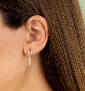 Close-up of double oval link earrings with polished gold and sparkling zircon stones