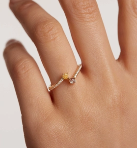 Macro shot of V-shaped rose gold chevron ring with dual gemstones and pave diamonds