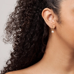 Minimalist S925 sterling silver pearl drop earrings with elegant gold finish on a model