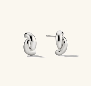 Détail macro de boucles d'oreilles torsadées en argent sterling S925 avec fini poli miroir