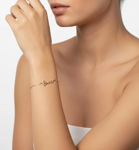 Detail of elegant S925 silver rose gold LOVE bracelet on a female wrist
