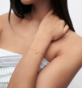 Détail d'un bracelet fin en argent S925 doré avec pendentif goutte et cristal de zircon
