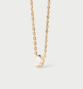 Gros plan sur un collier halo doré minimaliste orné d'un zircon rond brillant