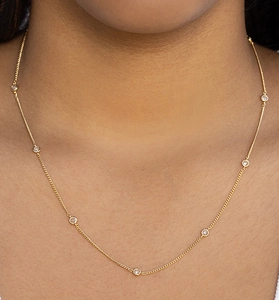 Gros plan du collier minimaliste en argent S925 doré avec sept pierres de zircon