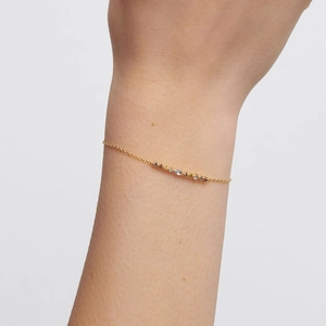 Minimalist gold S925 sterling silver bracelet with multi-colored zircons on model wrist