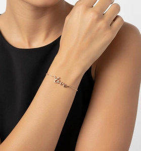 Detail of rose gold Love letter bracelet worn on wrist for an elegant minimalist look